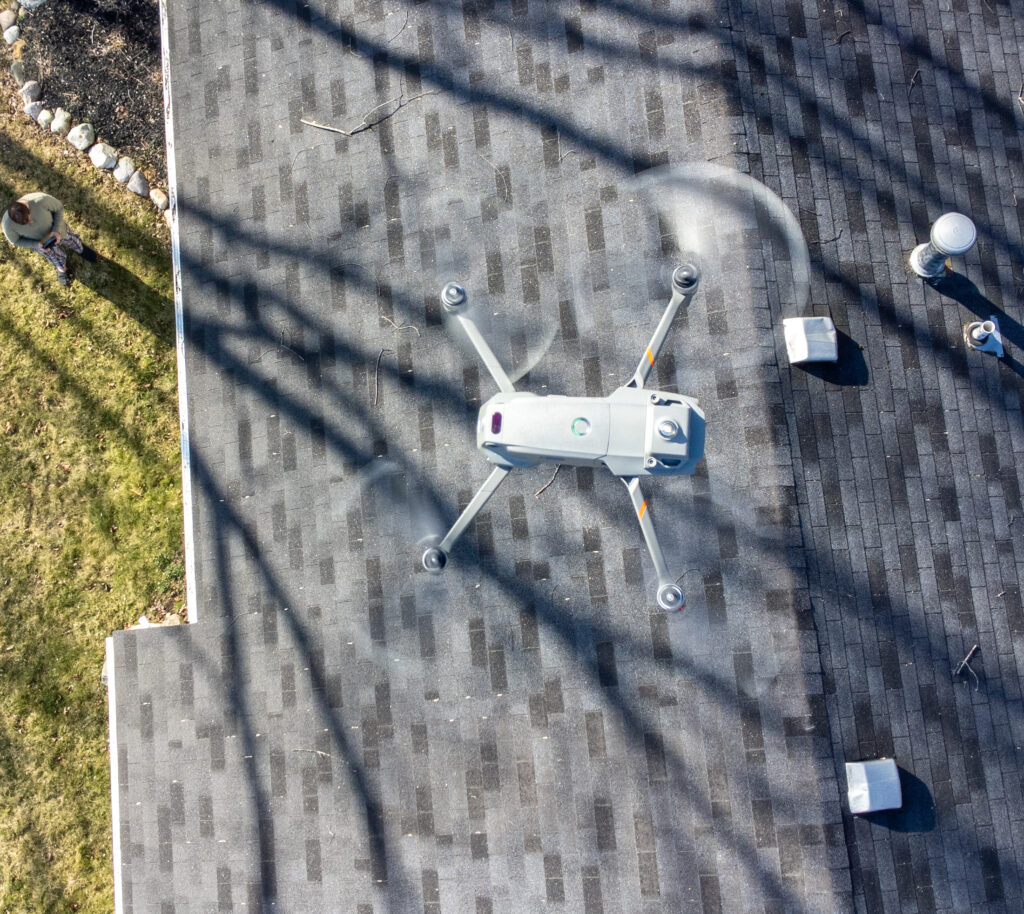 Drone hovering above a residential roof