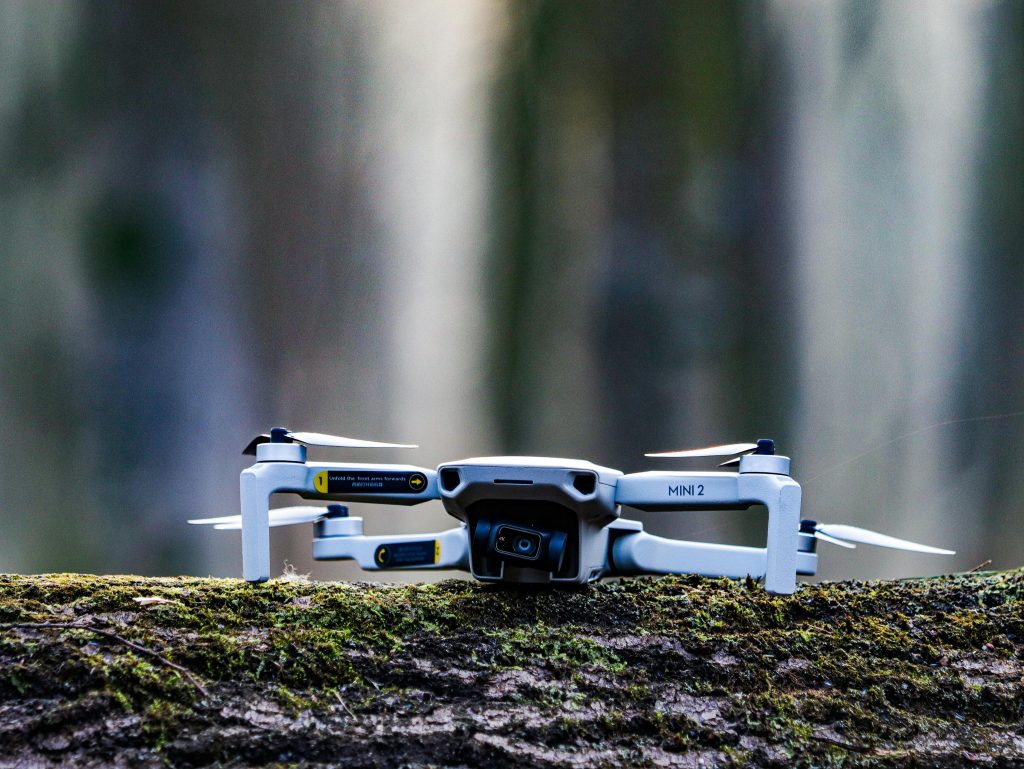 A small drone sitting on top of a tree stump